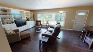 Large living room with white enamel built-in cabinetry and large window