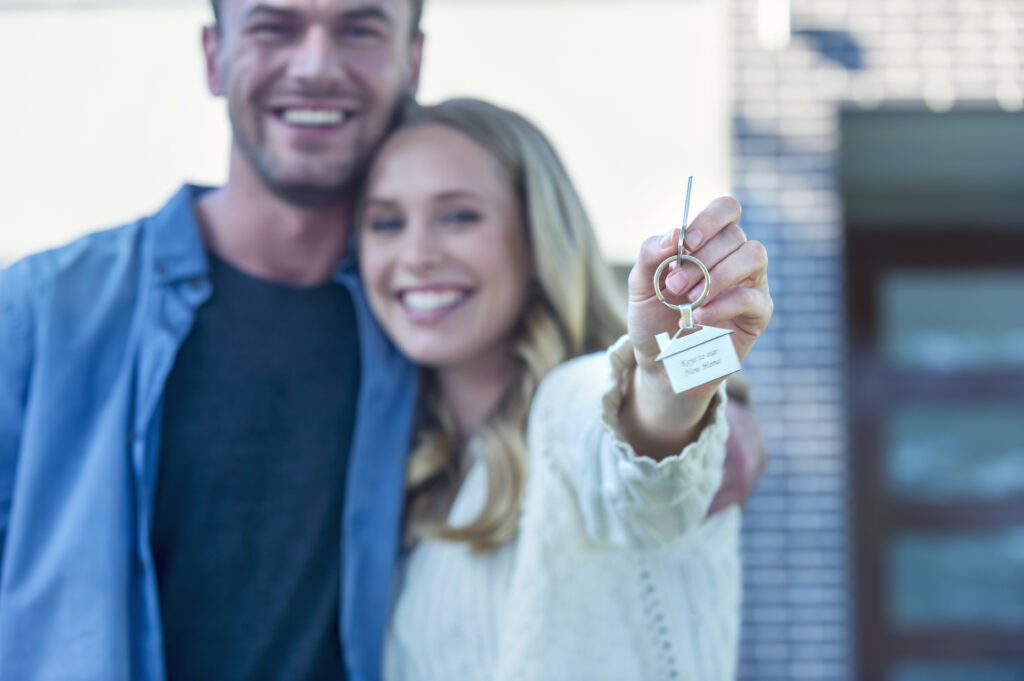 Stillwater MN teacher and spouse holding key to home they just purchased 