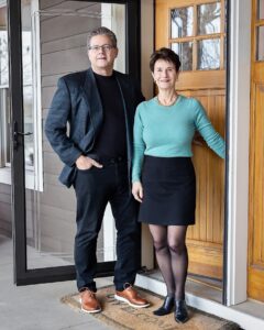 Realtors, John and Becky Durham of the Durham Executive Group brokerage standing in front of a home. www.durhamexecutivegroup.com