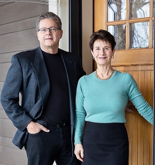 Realtors, John and Becky Durham standing in front of a home. www.durhamexecutivegroup.com